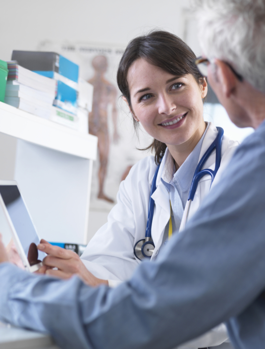 Doctor sharing health information on digital tablet with patient in clinic